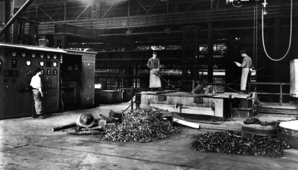 Arbeiter in Schutzkleidung auf der Ofenbühne im Elektrostahlwerk der August Thyssen-Hütte AG, um 1940.