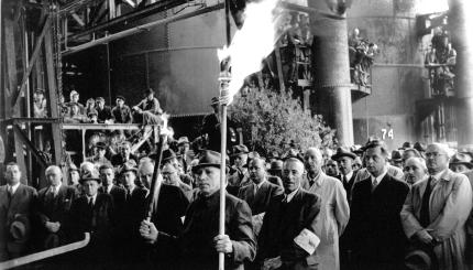 Feierstunde auf der Thyssen-Hütte am 7. Mai 1951 bei der Wiederinbetriebnahme des ersten Hochofens nach dem Krieg. Im Vordergrund der älteste Hochofenmann der damaligen Belegschaft.